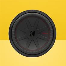 Front view of KICKER CompR 12 inch Subwoofer on two-tone yellow background