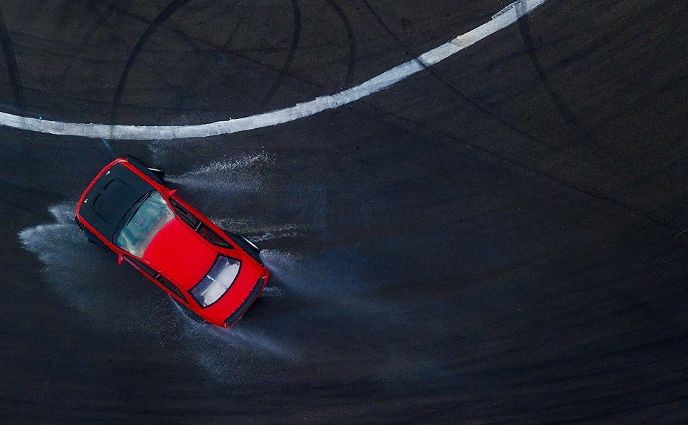 Red car drifting on wet street